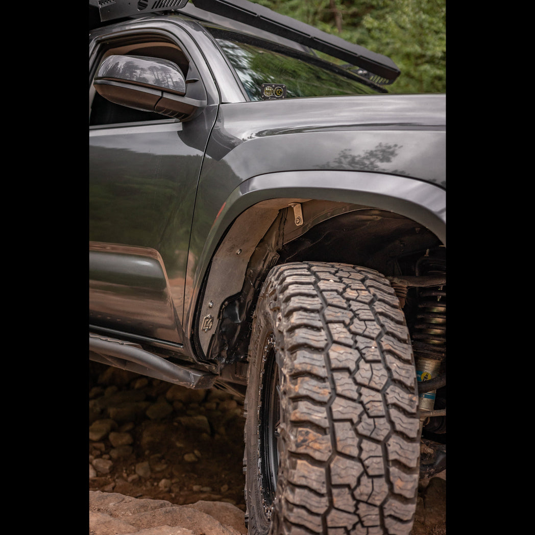 Close up view of a complete C4 Oversize Tire Fitment kit installed on a 3rd Gen Tacoma.
