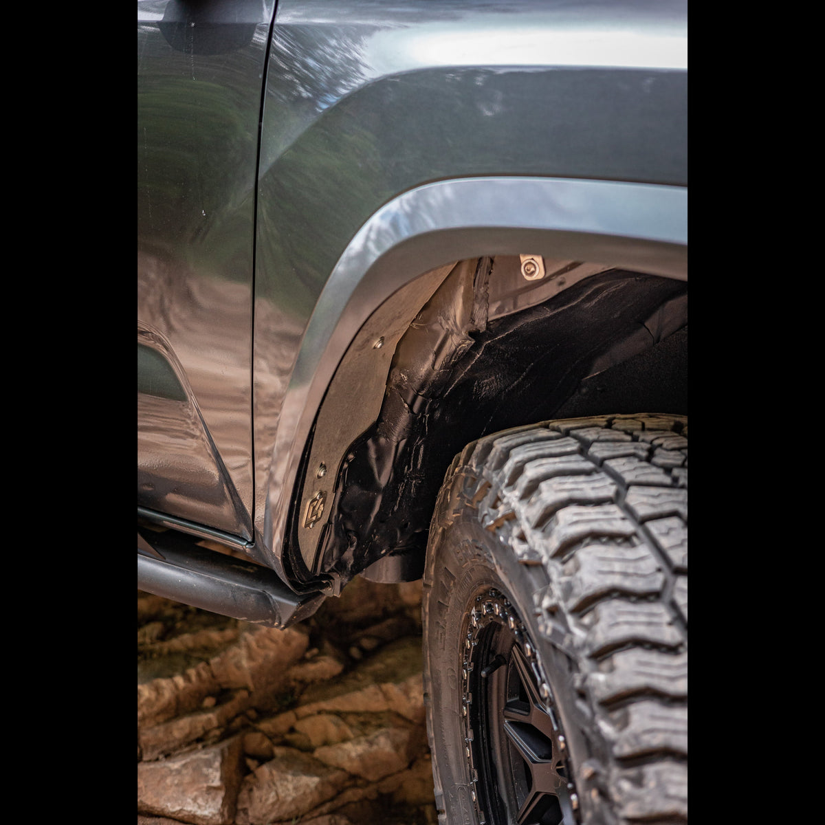 Look back through the rear of the passenger wheel well showing the installed C4 Oversize Tire Fitment kit.