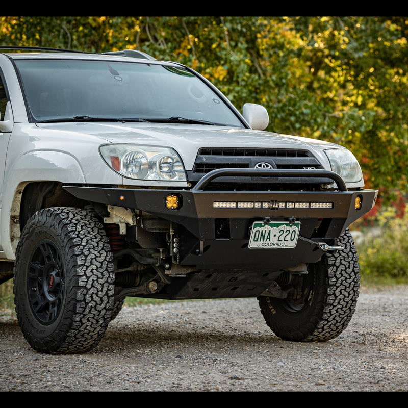 Passenger side angled front view of a white V8 4Runner with a C4 bumper installed.