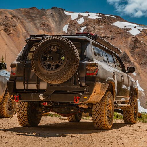 Passenger side rear view of the Overland rear bumper for the 4Runner from C4 Fabrications, showing off its half-width spare tire swing option. 
