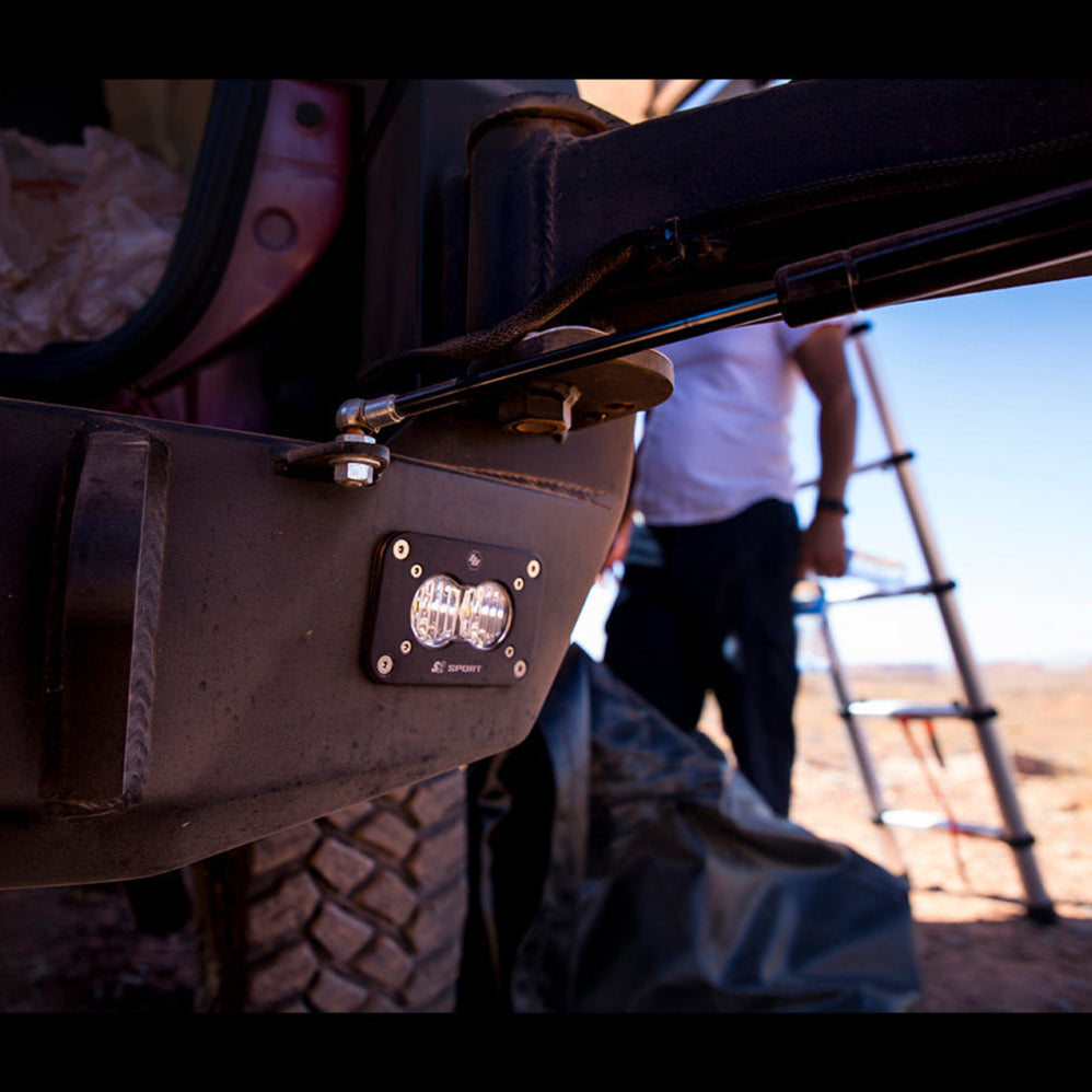 Low-angle view of the C4 rear bumper for the 5th Gen 4Runner showing a Baja Designs S2 Sport flush-mount LED light mounted to aid visibility at night.