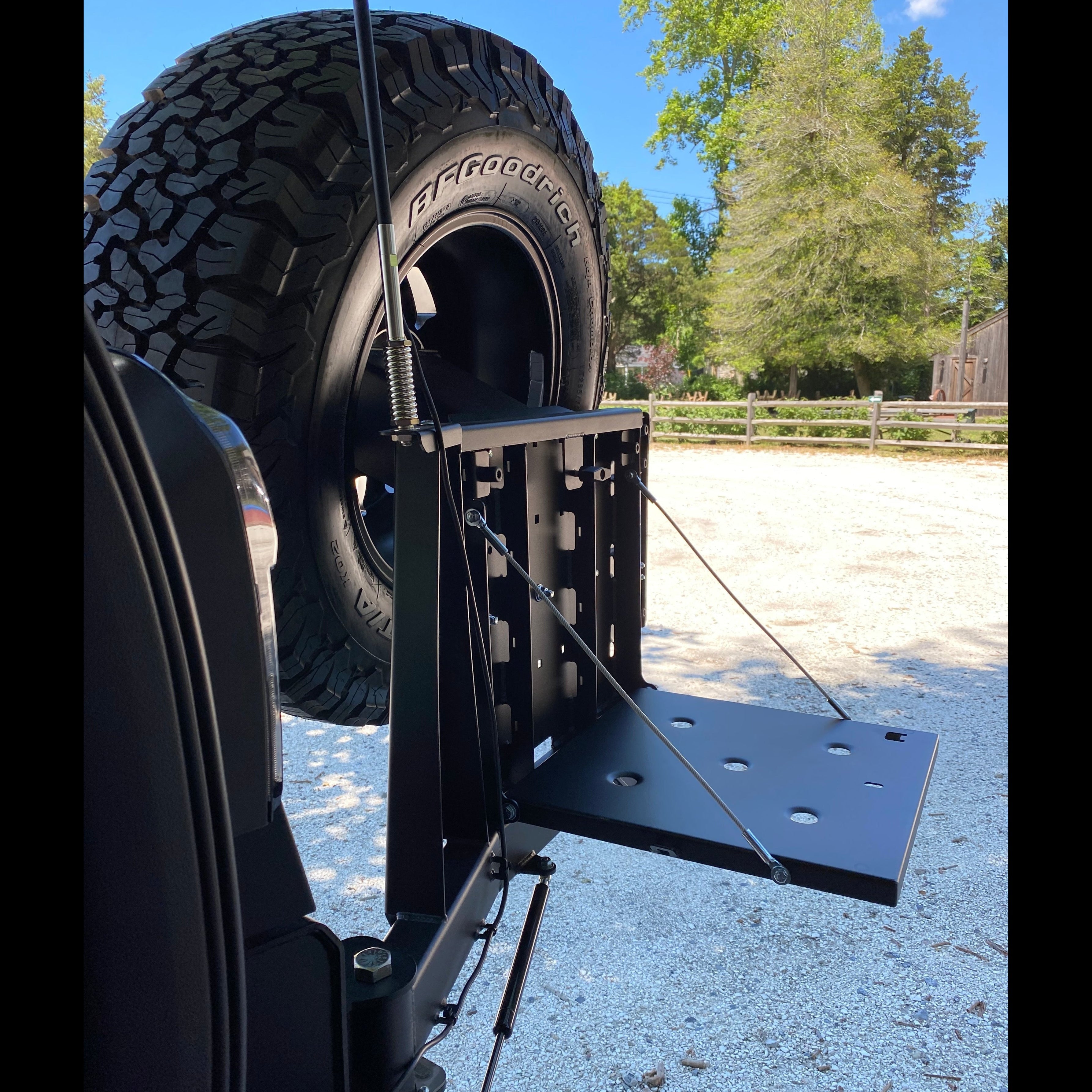 Side view of the fold-down table integrated into the swing-out on the 4Runner rear bumper made by C4 Fabrications.
