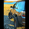 Look down the side of a grey 4Runner overlooking a lake, showing the kick-out at the rear of the C4 Rock Sliders.