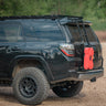 Quartering side rear angle of a black 4Runner with the C4 hatch ladder and a single RotopaX mounted to it.