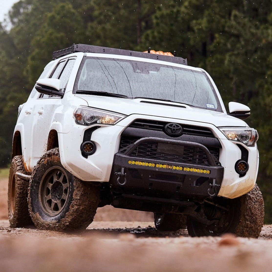 White 2014 4Runner offroading in mud and equipped with the Lo-Pro winch bumper manufactured by C4 Fabrication.