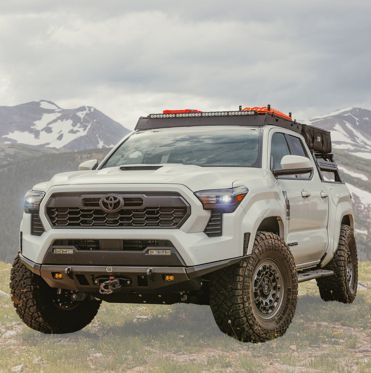 White 2024 Tacoma navigating a mountain road while equipped with the C4 Lo-Pro front winch bumper.