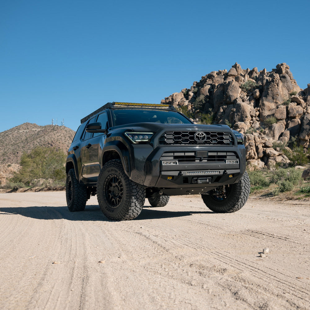 Black Toyota 6th Gen 4Runner with C4 Lo Pro Front Bumper on a dirt road with rocky mountains in the background