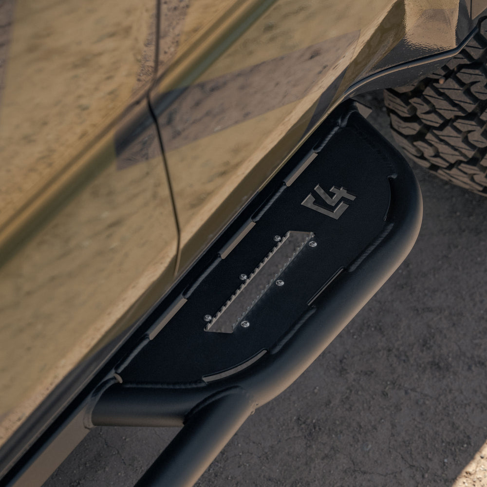 Close-up of Rock sliders for the 6th Gen Toyota 4Runner with C4 logo on a desert background