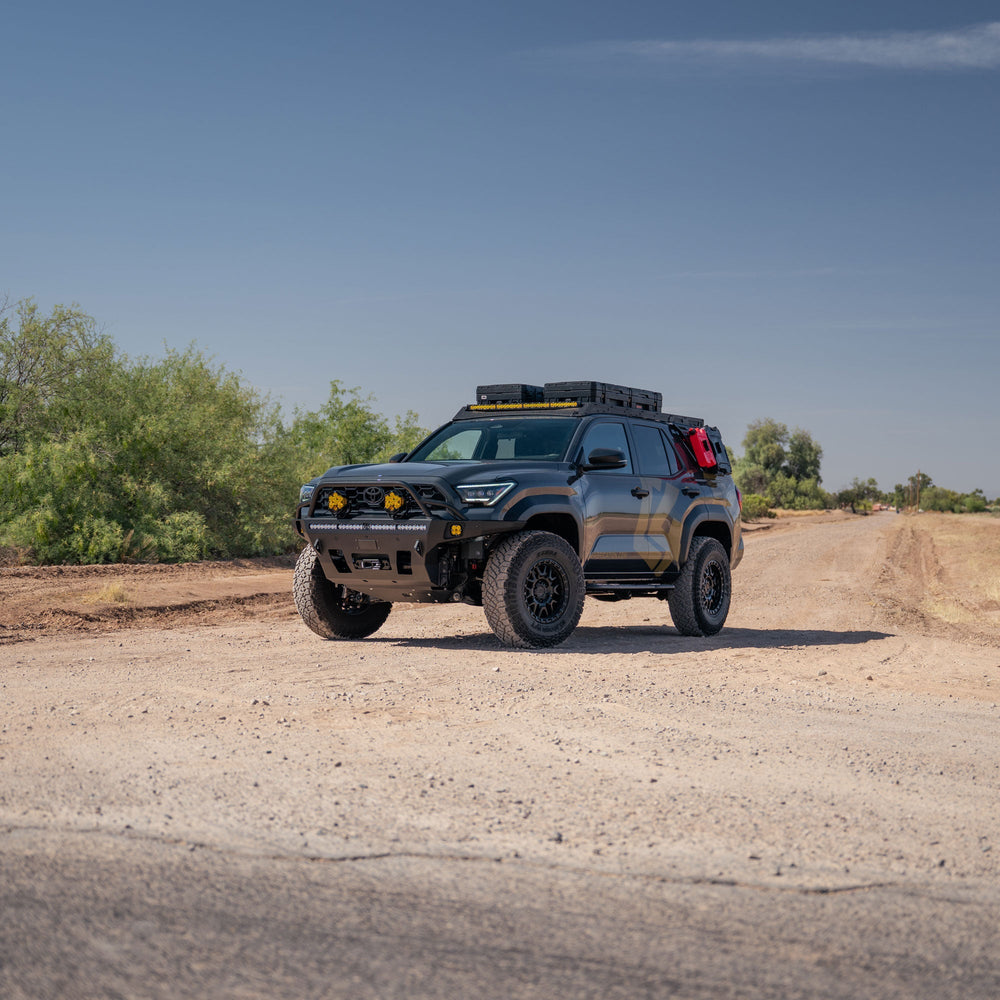 Farm road with our fully built-out 6th gen 4Runner with C4 Fabrication Overland Series Front Bumper, Roof Rack, Sliders, Molle Panels, and skid plates.