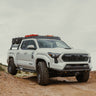 White 2024 Tacoma on a dirt road equipped with the affordable C4 Lo-Pro front winch bumper.