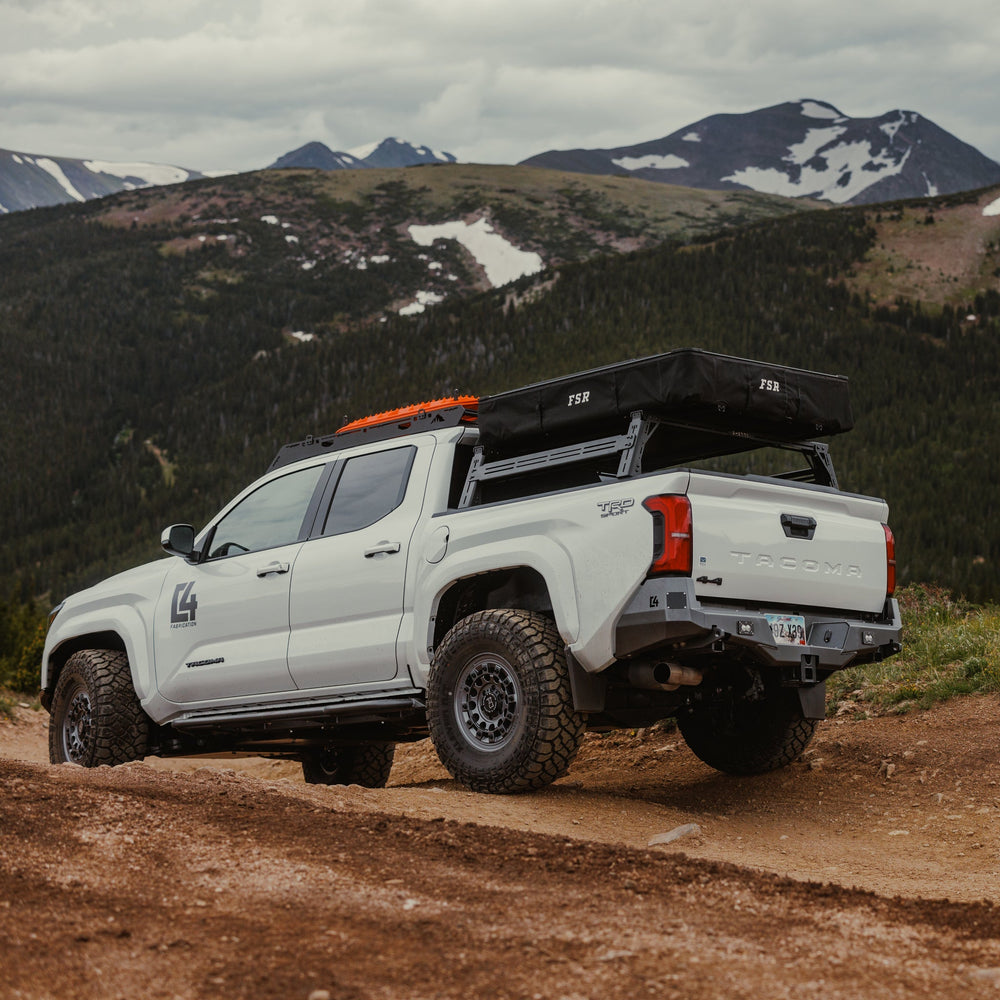Rear view of a white Tacoma exploring the mountains and well-equipped with overlanding gear and accessories.