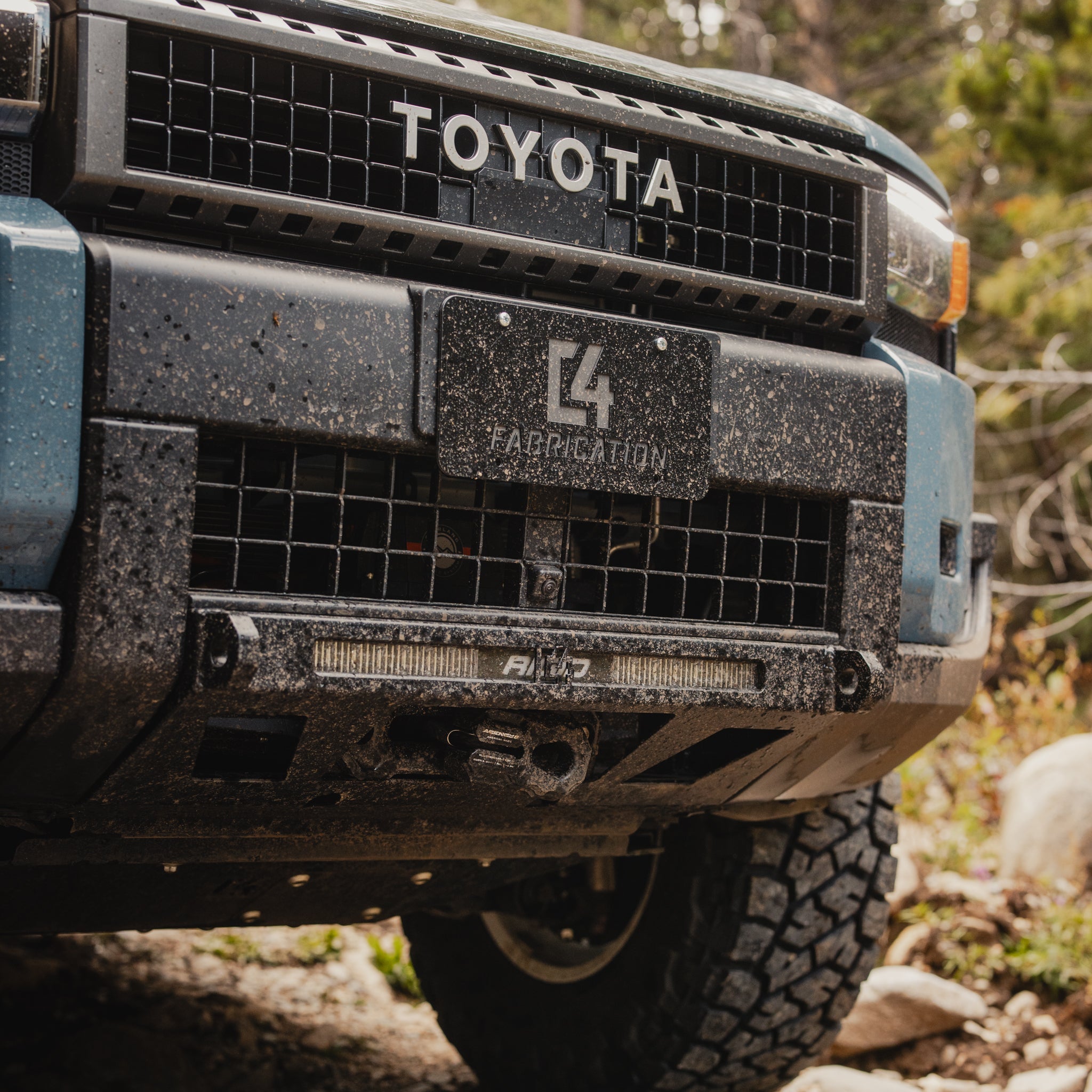 C4 Lo-Pro winch bumper installed on Land Cruiser LC250 and muddy from off-roading.