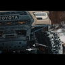 Close-up view of the Rock Runner bumper with the RCLT HD long travel rock crawling long travel system on a tan Tacoma. 