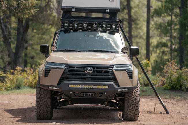 GX 550 fully equipped on camping trip with off road bumpers, roof rack, tent, light brackets, and molle panels.