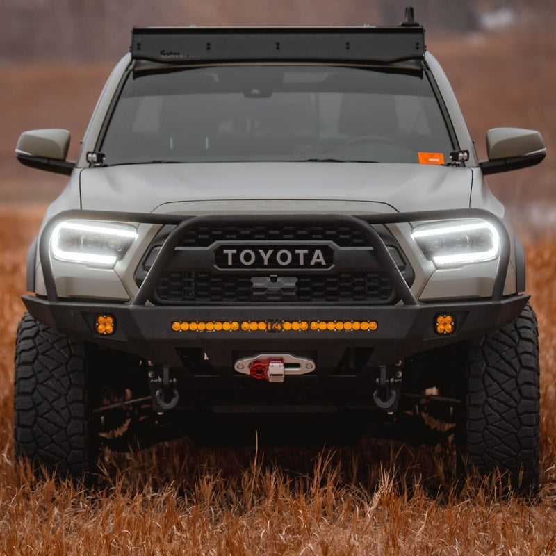 Straight on view of a Tan Tacoma with a roof rack and C4 Overland front winch bumper.