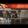 Close up view of the hidden hitch underneath the hinged and spring-loaded license plate frame on the C4 Overland rear bumper for the 2nd Gen Tacoma.