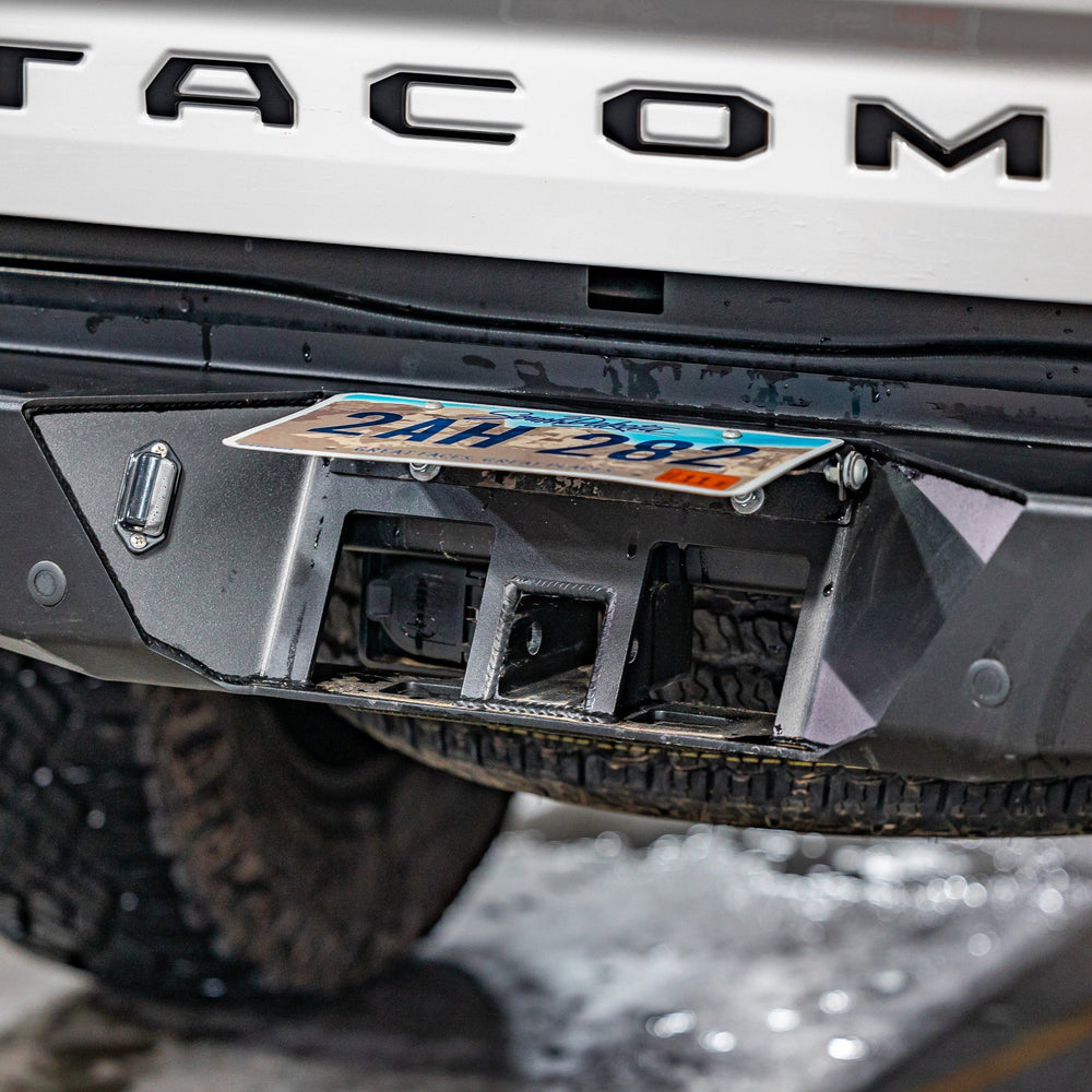 View of the concealed hitch that is employed by flipping up the license plate on the C4 Overland rear bumper for the Tacoma.
