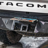 View of the concealed hitch that is employed by flipping up the license plate on the C4 Overland rear bumper for the Tacoma.