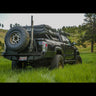 Wider view of a black Tacoma with the C4 high clearance bumper with spare tire swingout.