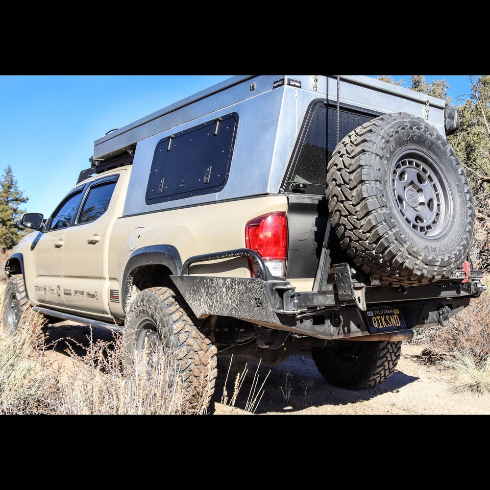 Tan four door Tacoma with a pop-top topper and the C4 High Clearance Rear Bumper.