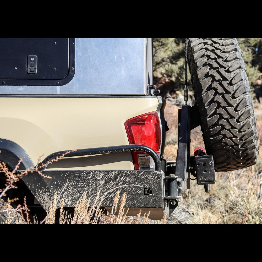 Side view of the C4 Overland High Clearance rear bumper with tire swing out on a Toyota Tacoma.