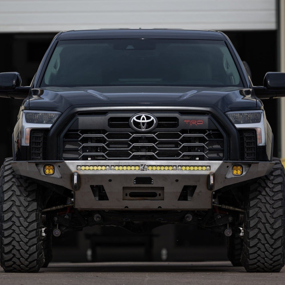 Straight-on view of a black 3rd Gen Tundra with a C4 Overland front bumper in raw steel. 