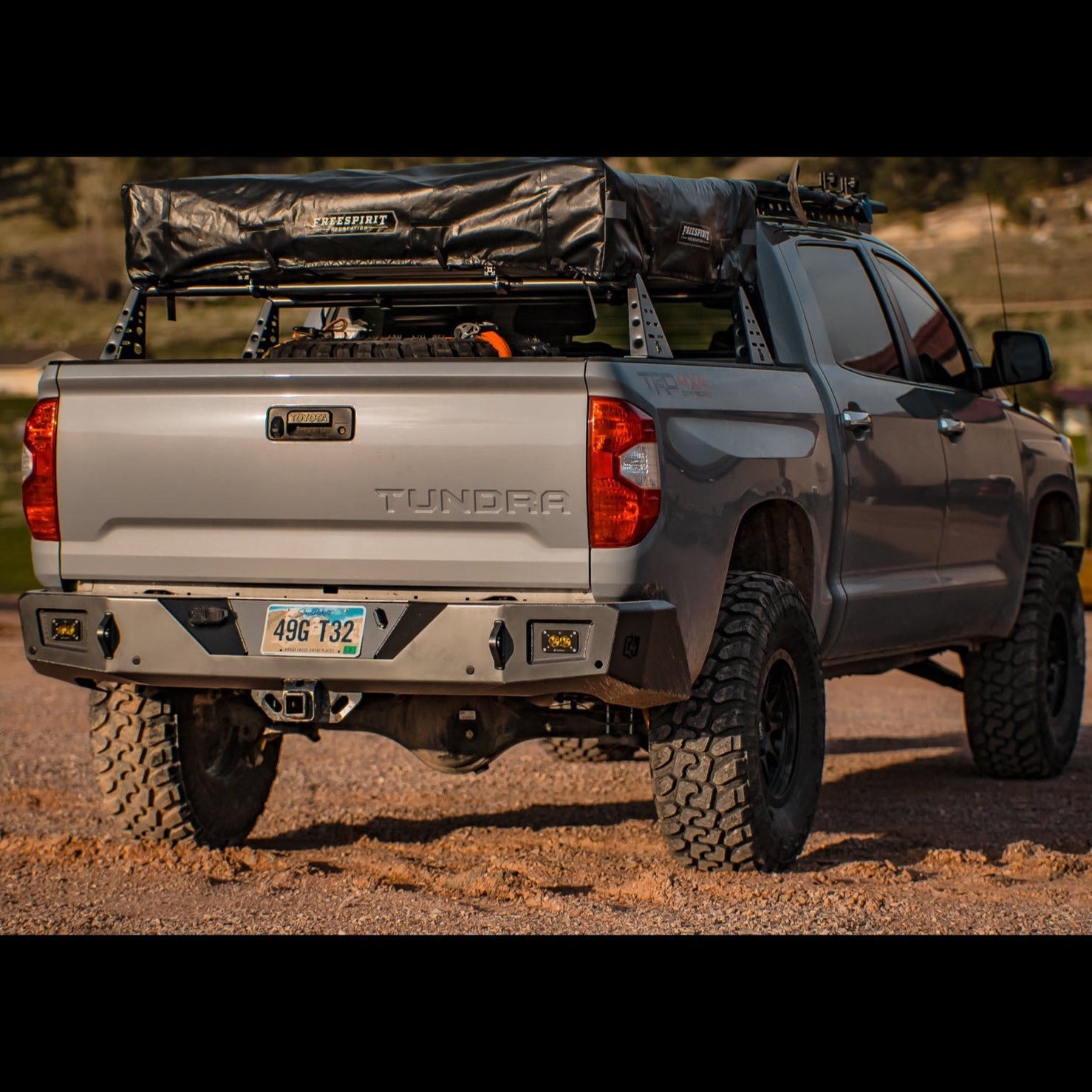 Modified Toyota Tundra with roof top tent installed on a bed rack and the C4 Overland rear bumper.