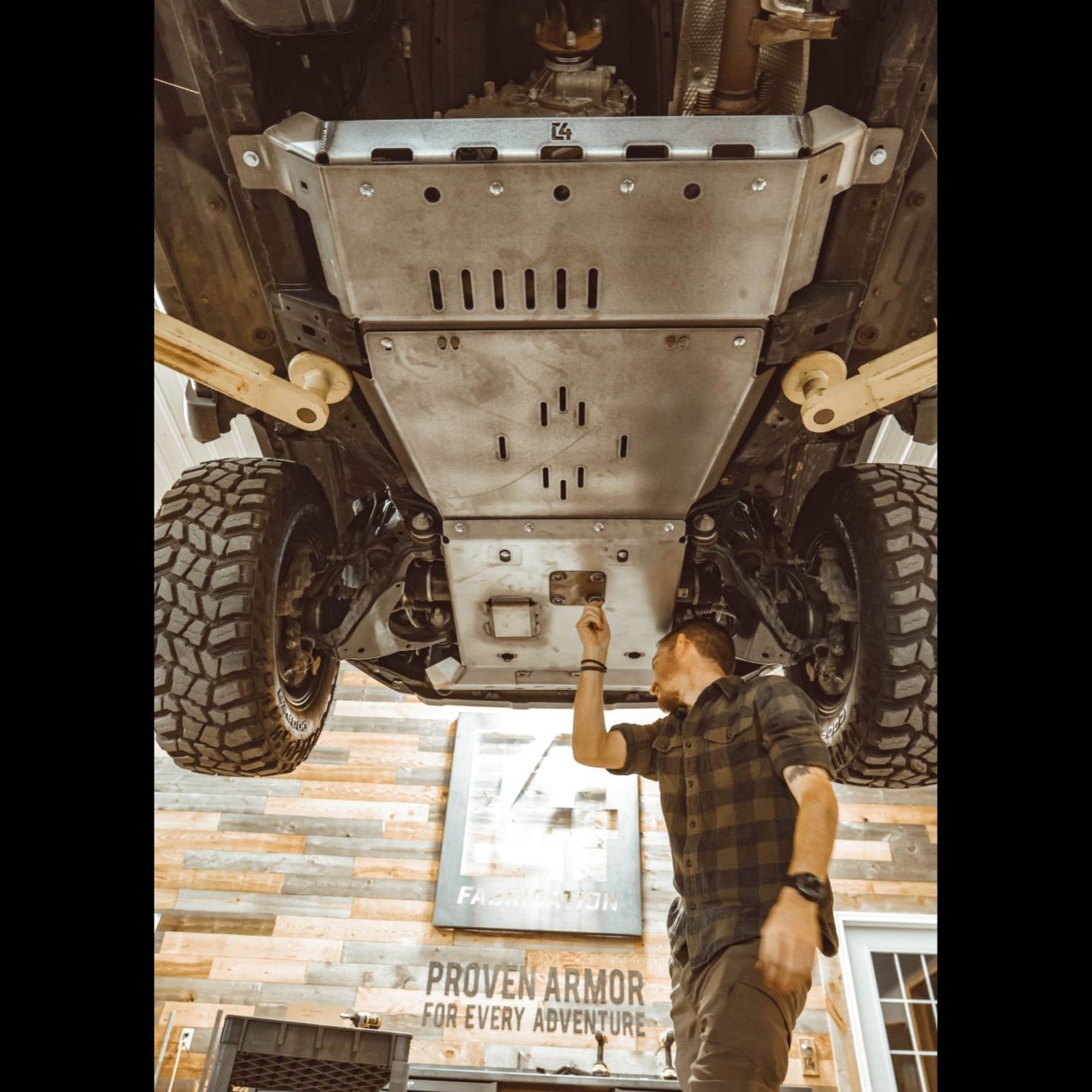 View from underneath and behind as the oil drain access panel is removed from the C4 full skid plate set for the 5th Generation 4Runner.