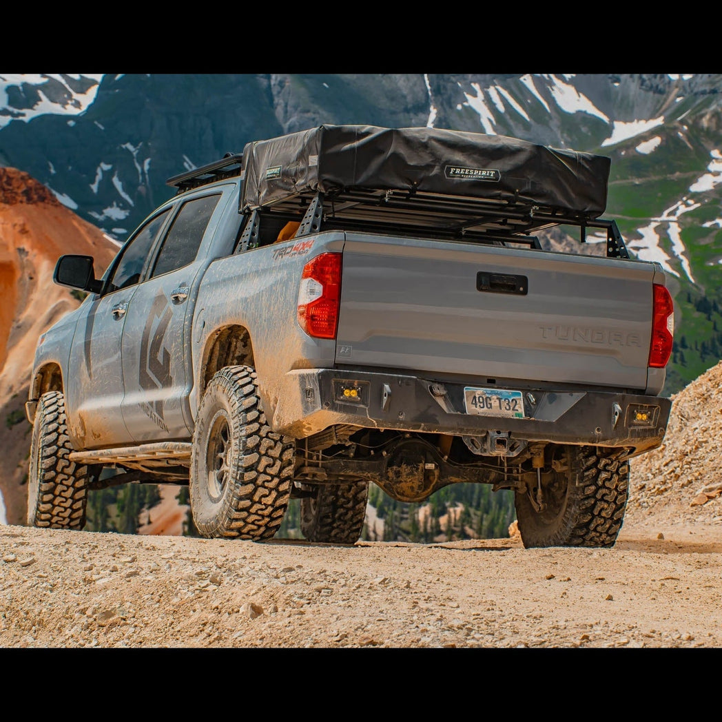 Closer view of the C4 Overland rear bumper on a Tundra exploring a mountain trail.